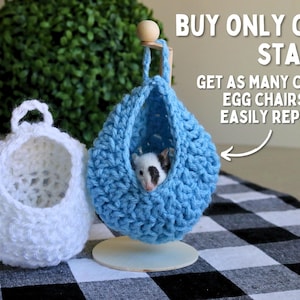 May include: Two crocheted hanging beds for small pets, one white and one blue. The blue bed has a small white and black pet inside. The text on the image reads "BUY ONLY ONE STAND! GET AS MANY COLOR EGG CHAIRS AND EASILY REPLACE!"