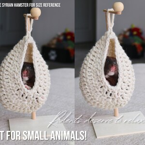 May include: A white crocheted hanging hammock for small animals, with a hamster inside. The hammock is suspended from a wooden stand with a small wooden ball on top. The text "Rodents deserve to relax too!" is written in cursive on the stand. The text "GREAT FOR SMALL ANIMALS!" is written in all caps below the stand.