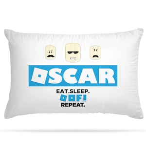 May include: White pillow with a blue and white design. The design features the word "OSCAR" in a blue box, three cartoon faces, and the text "EAT. SLEEP. OOF! REPEAT."