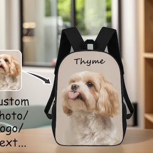 May include: Black backpack featuring a custom photo of a dog with its tongue out. The word "Thyme" is printed above the dog's image. The backpack also has the words "Custom Photo/Logo/Text..." printed on the side.