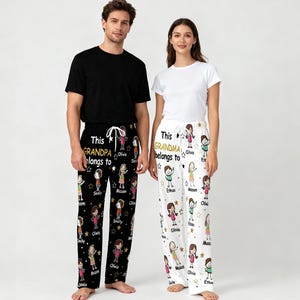 May include: Black pajama pants with the text "This Grandpa belongs to" and names, featuring cartoon illustrations of people and stars. The other pair of pajama pants are white with the text "This Grandma belongs to" and names, with similar illustrations.