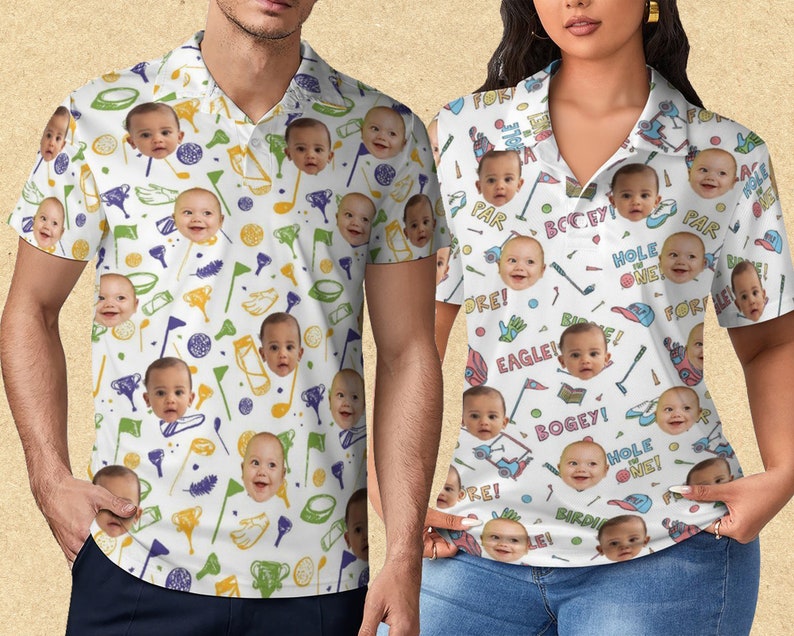 May include: White polo shirts with a golf-themed pattern. The shirts feature a repeating design of golf clubs, flags, and baby faces. Text includes "FORE!", "PAR", "EAGLE!", "BOGEY!", "HOLE ONE!", and "BIRDIE!"