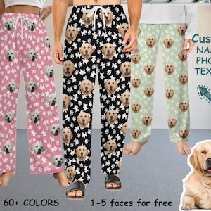 Op de afbeelding: Drie paar pyjamabroeken met een hondengezichtspatroon. De broeken zijn in roze, zwart en wit, en groen en wit. De tekst "Custom NAME/PHOTO TEXT..." is zichtbaar in de afbeelding. De tekst "60+ COLORS" en "1-5 faces for free" zijn ook zichtbaar in de afbeelding.