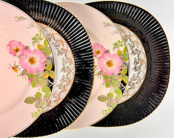 Juego de 4 platos de postre vintage desparejados, con ribete rosa y negro, ideales para recepciones.