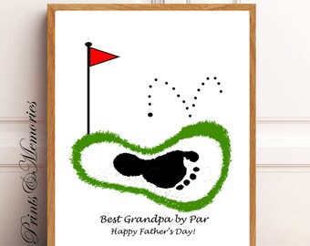 May include: A framed print with a golf theme. The artwork features a black footprint inside a green outline, a red golf flag, and the text "Best Grandpa by Par Happy Father's Day!" on a white background.