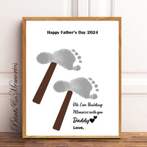 May include: A white printable Father's Day card with a gray footprint and a brown hammer. The text reads "Happy Father's Day 2024", "We Love Building Memories with you Daddy", and "Love,".