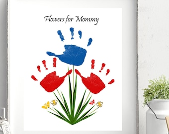 May include: Framed artwork featuring a handprint flower design. The artwork includes a blue handprint at the top, red handprints on either side, and green stems with yellow butterflies and flowers. The text "Flowers for Mommy" is at the top.