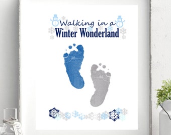 Può includere: Una stampa d'arte stampabile bianca con impronte di piedi blu e grigie, fiocchi di neve e il testo "Walking in a Winter Wonderland".