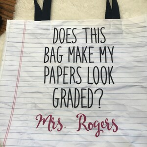 May include: White canvas tote bag with black text that reads "Does this bag make my papers look graded?" and "Mrs. Rogers" in pink text.