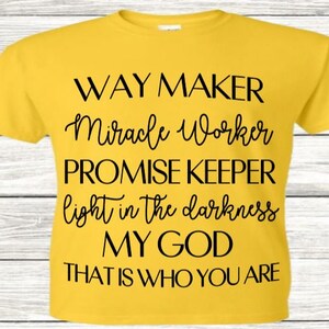 Puede incluir: Camiseta amarilla con texto negro que dice "WAY MAKER Miracle Worker PROMISE KEEPER light in the darkness MY GOD THAT IS WHO YOU ARE"