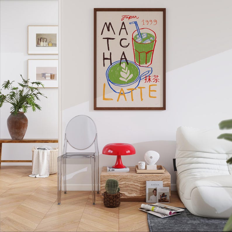 Peut inclure: Une illustration encadr&eacute;e d'un latte au matcha vert avec de la glace et une paille. Le texte sur l'affiche indique "Japon 1999 Matcha Latte" en lettres color&eacute;es. L'affiche est accroch&eacute;e &agrave; un mur blanc dans un salon.