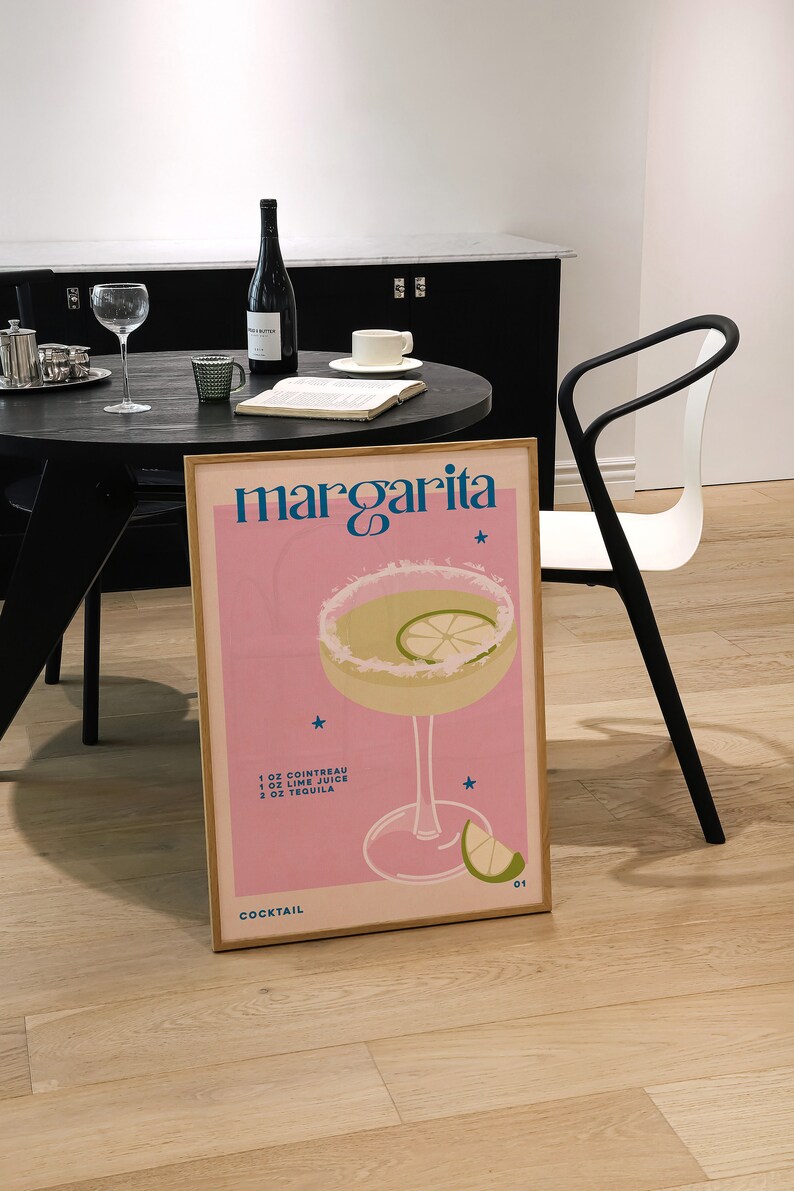 Peut inclure: Une affiche rose et blanche avec le texte "margarita" en bleu et blanc. L'affiche pr&eacute;sente un verre &agrave; cocktail avec une margarita, un quartier de citron vert et un motif d'&eacute;toile. La recette d'une margarita est indiqu&eacute;e sous l'image&nbsp;: 1&nbsp;oz de Cointreau, 1&nbsp;oz de jus de citron vert, 2&nbsp;oz de tequila. L'affiche comprend &eacute;galement le texte "Cocktail 01".