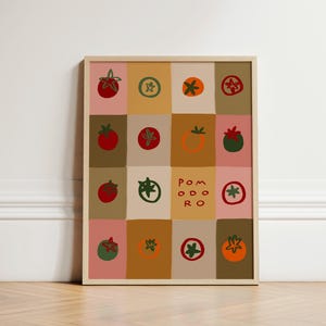 May include: A framed print featuring a grid of colorful tomato illustrations. Each square showcases a different tomato design in shades of red, green, and orange, set against a backdrop of pink, tan, and brown squares. The word "POMODORO" is also displayed.