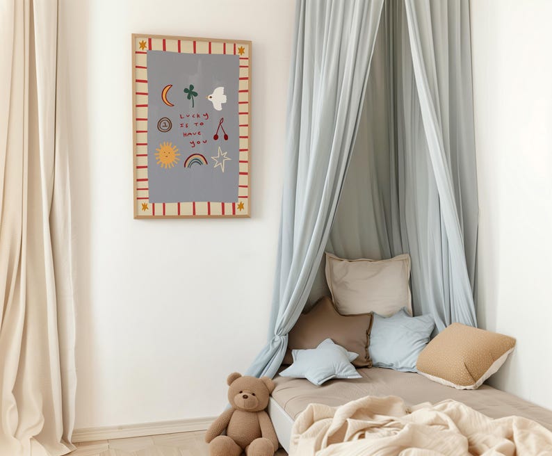 May include: A light blue canopy bed with a brown teddy bear sitting on the bed. The wall behind the bed has a framed print with a gray background and colorful illustrations of a sun, moon, rainbow, stars, and a bird. The print has the text "Lucky to have you".