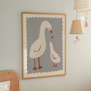 K&ouml;nnte beinhalten: Gerahmter Kunstdruck mit einer Illustration von zwei wei&szlig;en G&auml;nsen mit orangefarbenen F&uuml;&szlig;en und Schn&auml;beln vor hellblauem Hintergrund. Ein kleines rotes Herz schwebt zwischen den G&auml;nsen. Das Kunstwerk ist in hellem Holz gerahmt.