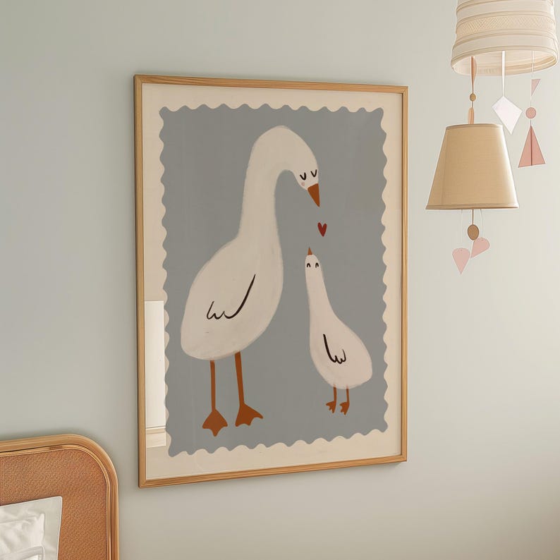 K&ouml;nnte beinhalten: Gerahmter Kunstdruck mit einer Illustration von zwei wei&szlig;en G&auml;nsen mit orangefarbenen F&uuml;&szlig;en und Schn&auml;beln vor hellblauem Hintergrund. Ein kleines rotes Herz schwebt zwischen den G&auml;nsen. Das Kunstwerk ist in hellem Holz gerahmt.