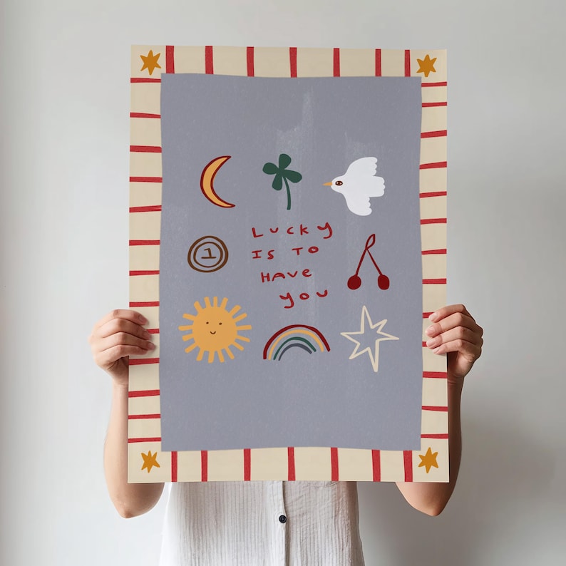 May include: A light blue poster with a red and white striped border. The poster features a variety of hand-drawn illustrations, including a crescent moon, a four-leaf clover, a white dove, a sun with a smiling face, a rainbow, a star, a cherry, and a number one inside a circle. The text on the poster reads "Lucky is to have you".