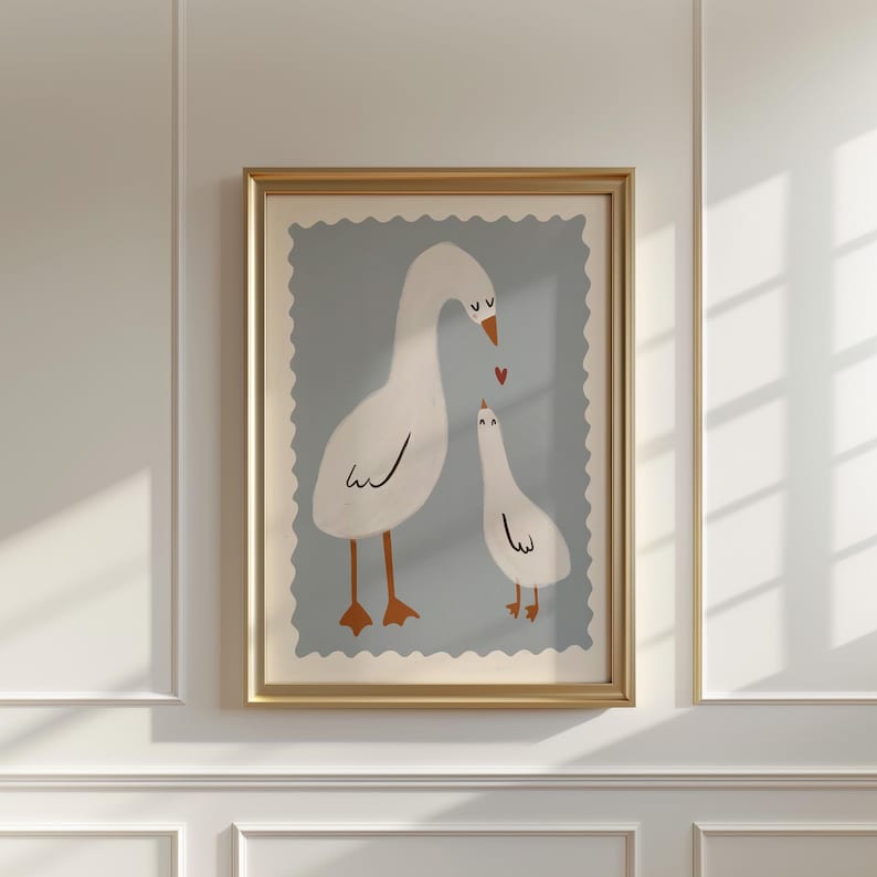 K&ouml;nnte beinhalten: Ein gerahmter Kunstdruck mit einer skurrilen Illustration von zwei wei&szlig;en G&auml;nsen mit orangefarbenen Beinen und Schn&auml;beln. Die G&auml;nse sind vor einem hellblauen Hintergrund mit einem gewellten Rand platziert, und ein kleines rotes Herz schwebt zwischen ihnen. Der Rahmen ist goldfarben.