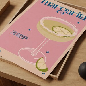 Peut inclure: Une affiche rose avec une illustration de cocktail margarita et le texte "Margarita" et "1 oz Cointreau, 1 oz Jus de citron vert, 2 oz Tequila".