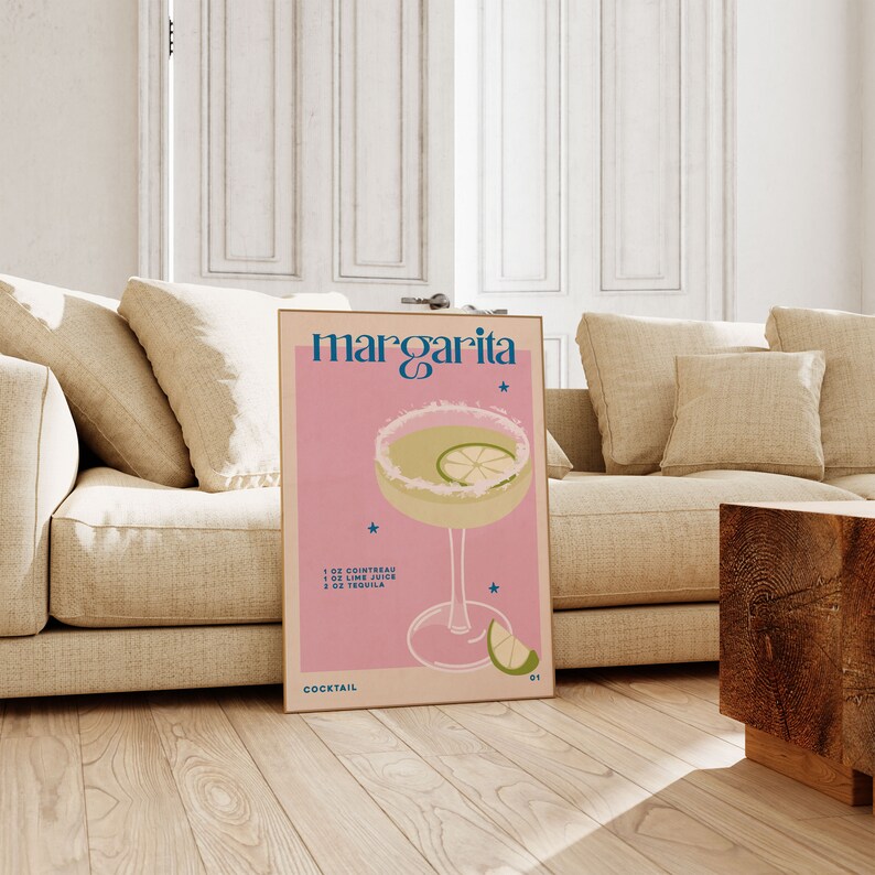Peut inclure: Une affiche rose et blanche avec le texte "margarita" en bleu et blanc. L'affiche repr&eacute;sente un verre &agrave; cocktail avec un quartier de citron vert et un fond rose. Le texte "1 oz Cointreau, 1 oz Jus de citron vert, 2 oz Tequila" est imprim&eacute; sous le verre. L'affiche comprend &eacute;galement le texte "Cocktail" et une petite &eacute;toile.