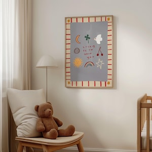 May include: A framed print with a light blue background and red and white stripes around the border. The print features a variety of hand-drawn illustrations, including a sun, a rainbow, a star, a clover, a bird, a crescent moon, and two cherries. The text "Lucky is to have you" is written in black.