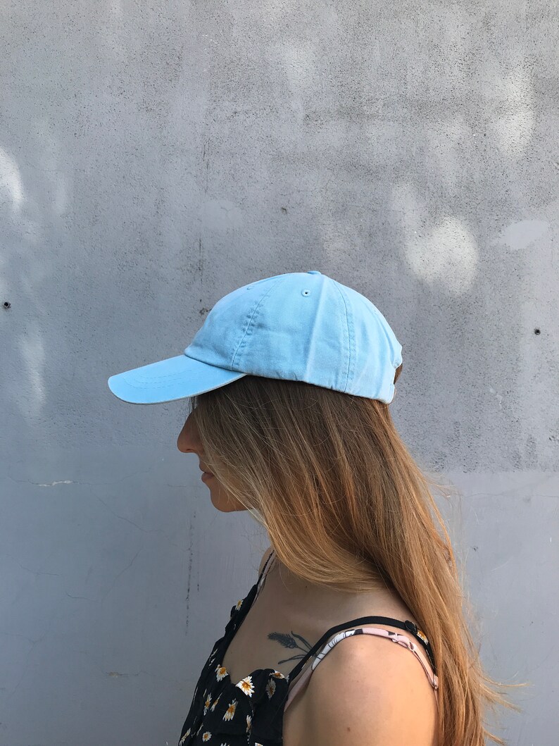 May include: A light blue baseball cap with a curved brim. The cap is made of a soft, cotton fabric.