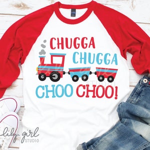 Pode incluir: Uma camiseta de beisebol de manga comprida branca com mangas vermelhas. A camiseta apresenta um trem de desenho animado vermelho, azul e branco com o texto "Chugga Chugga Choo Choo!" em vermelho e azul.