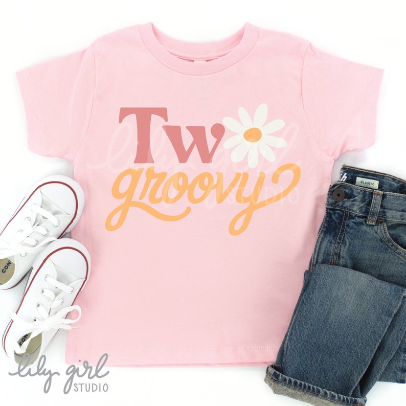 Pu&ograve; includere: Maglietta rosa per bambini piccoli con il testo "Two groovy" in arancione e rosa con una grafica di margherita bianca.