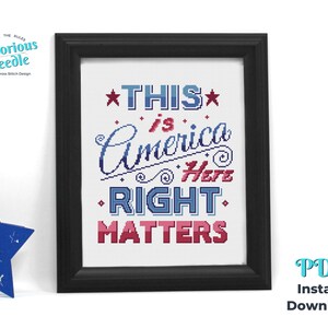 May include: Cross stitch pattern featuring the text "This is America Here Right Matters" in red, white, and blue. The pattern is framed in a black frame.