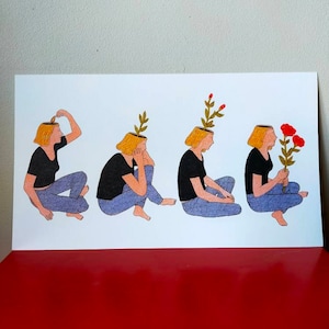 Peut inclure: Une impression représentant quatre figures en série, chacune avec une plante poussant de sa tête. Les personnages portent des hauts noirs et des jeans bleus. La dernière figure tient des fleurs rouges. L'œuvre est sur fond blanc.