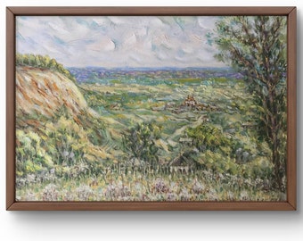 May include: A framed oil painting depicting a landscape scene with a hill, trees, and a distant village. The sky is cloudy and the colors are muted.