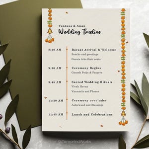 Pu&ograve; includere: Un cartoncino color crema con la scaletta del matrimonio e il testo Vandana & Aman Wedding Timeline, una linea verticale arancione e ghirlande di fiori di calendula con campanelle dorate ai lati. Il programma elenca gli eventi dalle 8:30 alle 11:45.