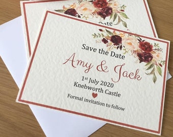 Op de afbeelding: Save the date-kaart met een bloemmotief in tinten rood, roze en groen. De kaart luidt "Save the Date Amy & Jack 1 juli 2020 Knebworth Castle Formele uitnodiging volgt."