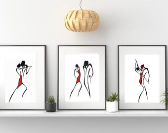 Op de afbeelding: Drie zwart ingelijste prints van lijntekeningen van dansende paren. De dansers zijn in silhouet met rode accenten. De prints hangen aan een witte muur.