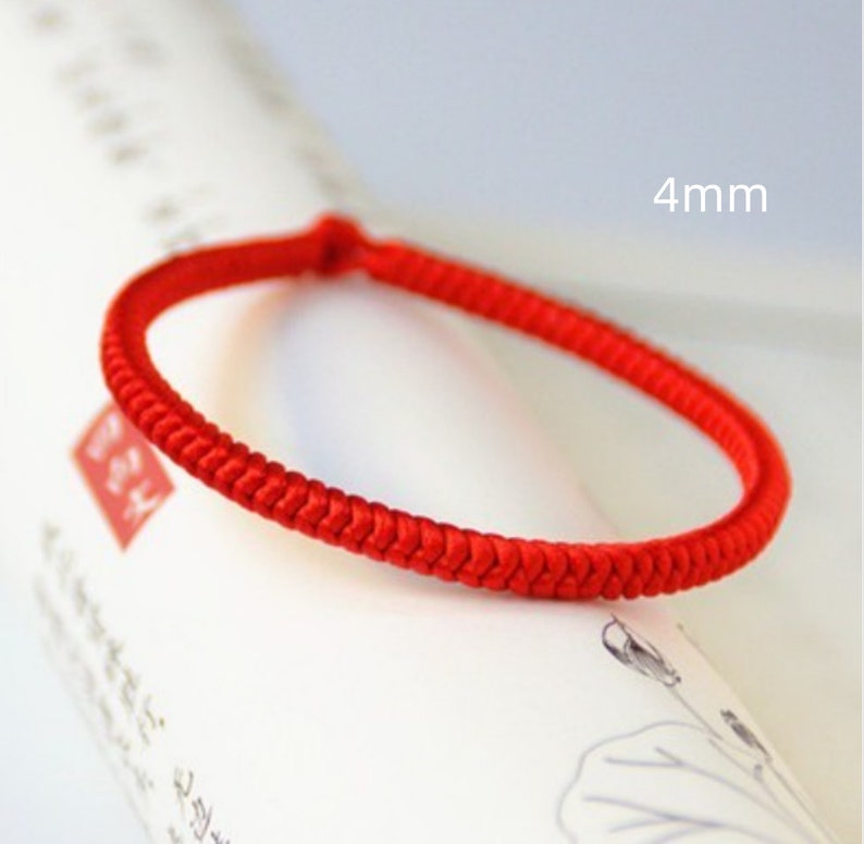 May include: A red braided bracelet made of string, 4 mm in width.