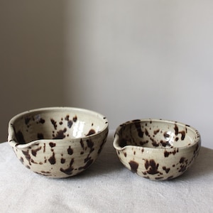 Two handmade ceramic matcha bowls in speckled Nordic glaze, showing two different sizes, one medium sized and one large.