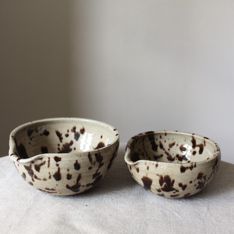 Two handmade ceramic matcha bowls in speckled Nordic glaze, showing two different sizes, one medium sized and one large.