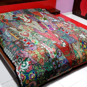 May include: A colourful patchwork quilt featuring a variety of fabrics and embellishments, including sequins, embroidery, and beads. The quilt is made in a traditional style and features a mix of floral and geometric patterns.