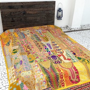 May include: A yellow, multi-coloured patchwork quilt with intricate embroidery and floral patterns. The quilt is made of various fabrics and textures, creating a unique and bohemian style.