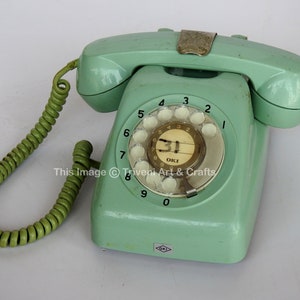 May include: A vintage green rotary dial phone with a green coiled cord. The phone has a white dial with black numbers and a small white label with the text "31" and "OKI".