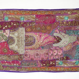 Könnte beinhalten: Ein farbenfroher Patchwork-Wandteppich mit einem violetten Rand. Der Teppich besteht aus verschiedenen Stoffen und ist mit Pailletten, Perlen und Stickereien verziert. Der Teppich zeigt eine Vielzahl von Farben, darunter Pink, Rot, Orange, Grün und Blau.