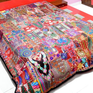 May include: A colourful patchwork quilt featuring a range of fabrics and embroidery. The quilt is composed of numerous squares and rectangles, each with a distinctive design. The quilt is a vibrant blend of colours, including red, orange, yellow, green, blue, purple, and pink.