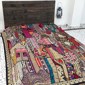 May include: A colourful patchwork quilt featuring a variety of fabrics and textures. The quilt is made up of many different pieces of fabric, each with its own unique pattern and colour. The quilt is a beautiful example of handmade craftsmanship.