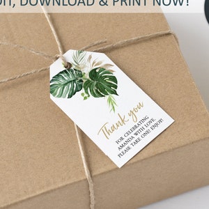 May include: A brown gift box with a white and green thank you tag tied with twine. The tag features a watercolor illustration of tropical leaves and the text "Thank you for celebrating Amanda with love. Please take one! Enjoy!"