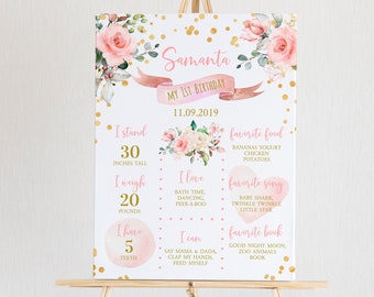 Könnte beinhalten: Ein rosa-goldener Meilenstein-Poster zum ersten Geburtstag mit floralen Dekorationen. Das Poster enthält den Namen Samanta, das Datum 11.09.2019 und Details über die Größe, das Gewicht, die Anzahl der Zähne, die Lieblingsessen, Lieder und Bücher des Kindes.
