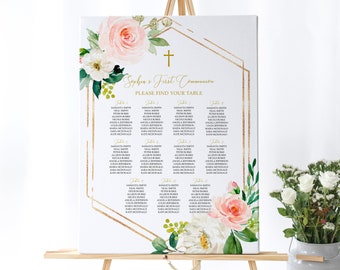 May include: A white canvas with a gold geometric frame and floral accents. The text "Sophia's First Communion" and "Please Find Your Table" is printed in gold. The canvas is on an easel and has a seating chart for a communion party.