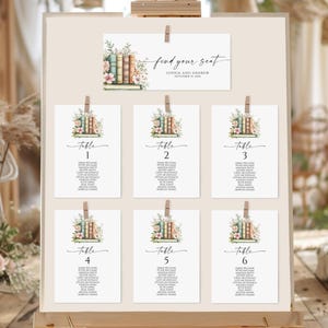 Puede incluir: Plano de asientos de boda con tema floral y de libros. El gráfico incluye una tarjeta superior con el texto "find your seat" y seis tarjetas de mesa numeradas del 1 al 6. Cada tarjeta presenta una pila de libros y detalles florales.