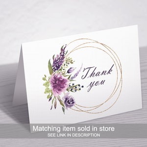 May include: A white card with a gold circle and purple watercolor flowers. The text "Thank you" is inside the circle.
