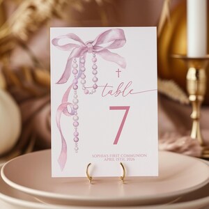 Könnte beinhalten: Eine weiße Keramik-Tasse mit schwarzem Henkel und dem Text "But First, Coffee" in schwarzer, fetter Schrift. Die Tasse steht auf einer weißen Oberfläche.