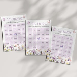 May include: Three purple and white baby bingo cards with a floral and butterfly design. The cards have a grid of squares with baby-related items listed in each square. The text on the cards reads "baby bingo".